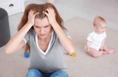 年轻母亲患有产后抑郁症和小婴儿在房间里