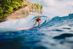 冲浪板上的女人骑着浪。冲女在海洋中
