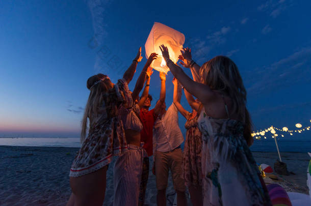 年轻的 millenials 在海滩上举行和点燃天空灯笼<strong>元宵节</strong>