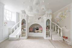 宽敞的儿童房间的内部。装饰城堡与床里面, 游戏滑动和台阶
