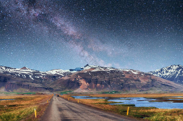 梦幻般的星空和银河。在冰岛南部连接 Jokulsarlon 泻湖和大西洋的通道上的桥.