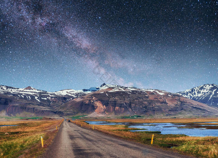 梦幻般的星空和银河。在冰岛南部连接 Jokulsarlon 泻湖和大西洋的通道上的桥.