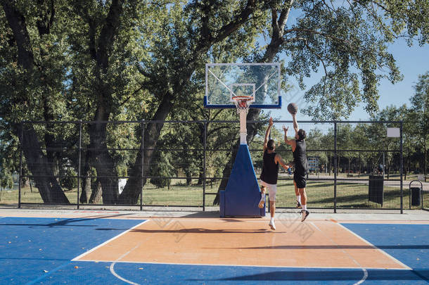 两名年轻球员在户外球场上<strong>打篮球</strong>.