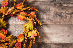 在木制背景上的秋天花环。感恩节的概念。复制空间