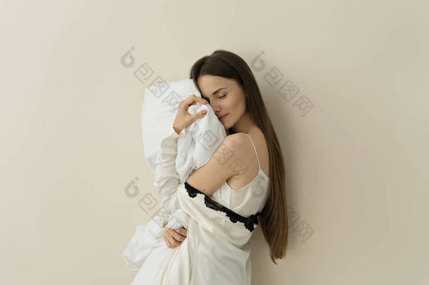 年轻的黑发妇女的纵向抱枕头