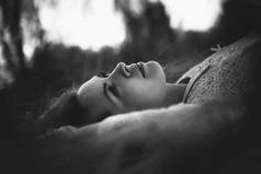 黑白色照片一个女孩躺在田野上的日落背景.