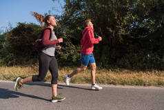 年轻夫妇一边在乡间小径上慢跑一边享受健康的生活方式、运动和健身的概念