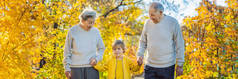 秋天公园里的老夫妇带着小孙子。大祖母, 曾祖父和曾孙横幅, 长格式