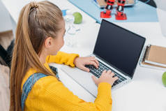女学生坐在办公桌前, 在笔记本电脑键盘上打字, 在词干课
