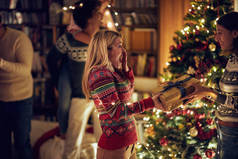 快乐的女孩在圣诞节给她的朋友女孩送去礼物。庆祝圣诞节和新年的概念