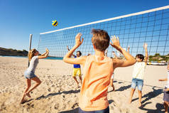 在阳光明媚的日子里, 沙滩排球比赛中, 运动中的少女将球传给网