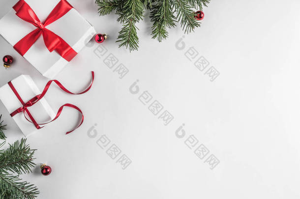 创意框架由圣诞冷杉分枝在白纸背景与红色装饰, 松果。圣诞节和新年主题。平面布局, 顶部视图