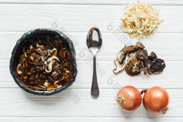 在白色木制背景上的<strong>勺子</strong>和成分的传统<strong>蘑菇汤</strong>的顶视图
