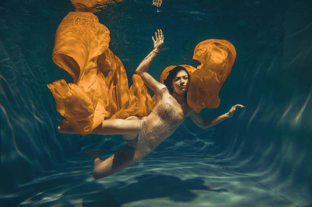 可爱的运动女孩游泳水下<strong>作为</strong>一个自由潜水员在纯粹的连身裤单独