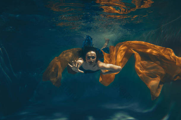 可爱的运动女孩游泳水下作为一个自由潜水员单独
