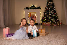 小男孩和女孩打开圣诞礼物新年冬天圣诞树