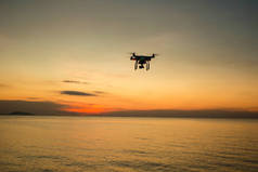 在夕阳西下的背景下,人物形象尽收眼底. 在夜空中飞行的无人驾驶飞机。 有数码相机的Uav Drone 飞行相机拍摄照片和录像。携带相机的无人机拍摄