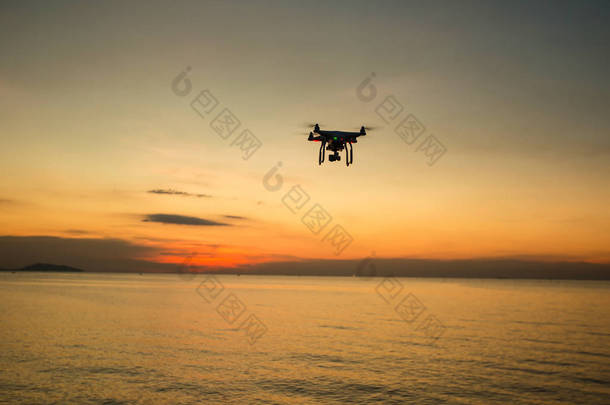 在夕阳西下的背景下,<strong>人物形象</strong>尽收眼底. 在夜空中飞行的无人驾驶飞机。 有数码相机的Uav Drone 飞行相机拍摄照片和录像。携带相机的无人机拍摄