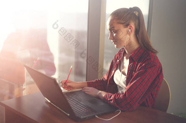 使用在线教育服务的学生。年轻的妇女在笔记本电脑显示观看培训<strong>外语</strong>课程和在笔记本笔记。现代学习技术理念.