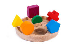 一个木制玩具儿童分拣器的照片，其木制细节呈几何形状（矩形、正方形、圆形、三角形），在白色孤立的背景中以不同的颜色出现