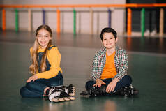 穿着溜冰鞋微笑的孩子们在一起玩的室内镜头