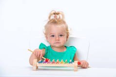 可爱的微笑的孩子小金发碧眼的女婴玩音乐玩具木琴孤立在白色背景.