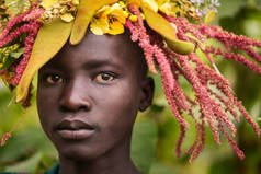 埃塞俄比亚基比什-2018年8月22日: 来自苏米部落的身份不明的年轻人, 拥有休假和鲜花的天然装饰。苏尔米也被称为苏瑞或苏尔马