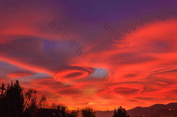 壮观的透镜云的日落描绘了橙色, 黄色和<strong>紫色</strong>的天空, 透镜状的云是由于水蒸气的扩散, 太阳的红光穿过水晶<strong>大气</strong>