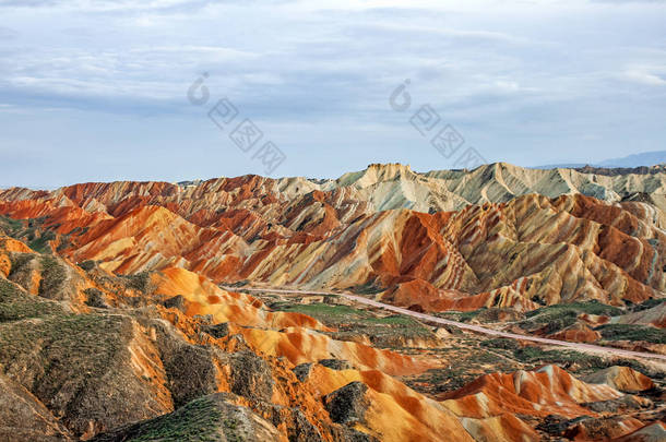 梦幻般的彩虹山地质公园的景色。甘肃省张丹霞地貌地质公园。阳光明媚的日子里, 山谷里的犀利高峰和道路.