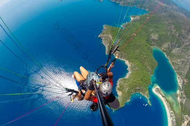 在天空中<strong>滑翔伞</strong>。在阳光明媚的日子里, <strong>滑翔伞</strong>在海上与蓝色的水和山脉一起飞行。土耳其奥卢德尼兹<strong>滑翔伞</strong>和蓝色泻湖鸟图。极限运动。景观
