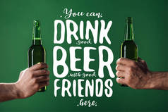 裁剪的看法的男人拿着啤酒瓶附近, 你可以喝好啤酒与好朋友在这里写在绿色背景