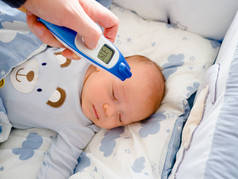 母亲, 家长正在检查生病婴儿的体温, 高烧生病的孩子躺在床上, 拿着温度计, 额头上的压缩冷却垫