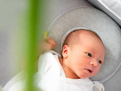 可爱的新生混合种族婴儿躺在床上与婴儿枕头为新生儿呼吸保护平头综合征。新生，家庭观念