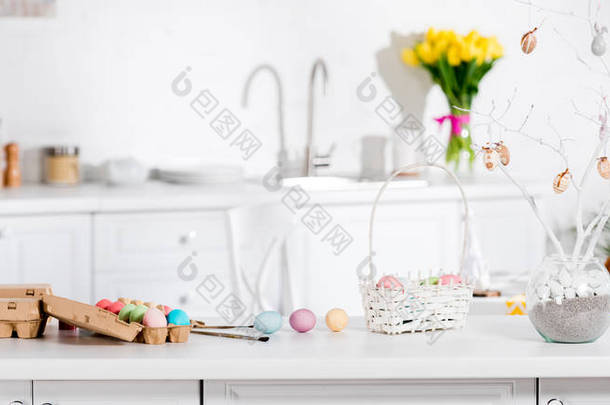 桌子上的柳条篮、彩绘鸡蛋和复活节树全景拍摄