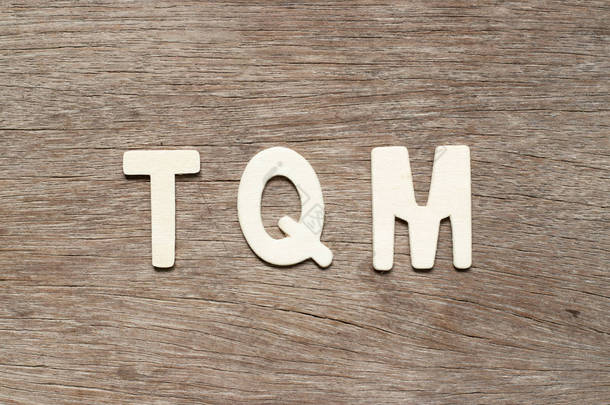字母字母以词 Tqm (总质量管理的简称) 在木头背景