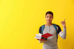 非洲裔美国小学生与书和提高食指在颜色背景