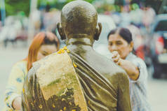 泰国北碧府-4月17日: 不明身份的人淋浴僧人雕塑在宋干节