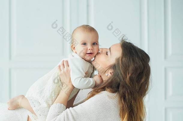 美丽的年轻母亲带着一个婴儿在她<strong>怀里</strong>站着一个幸福的家庭, 母亲的概念