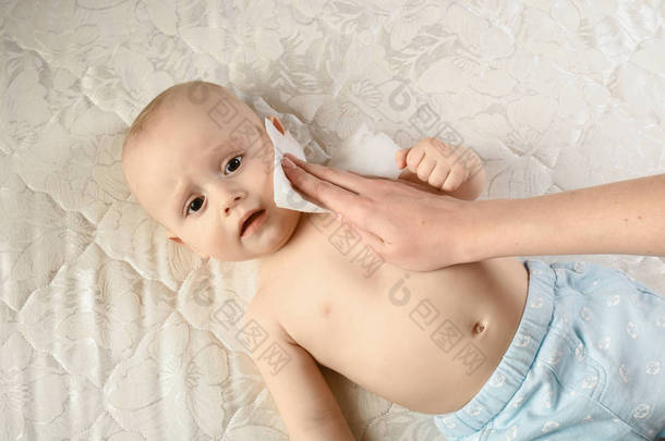 母婴护理-用湿巾擦拭婴儿的皮肤。有趣的婴儿情绪。婴儿护理卫生。清洁擦拭，干净，干净