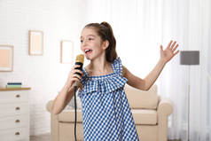 可爱的女孩在家里用麦克风唱歌