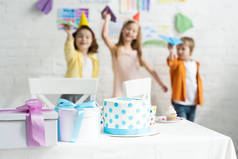 在生日聚会上, 孩子们在桌子上和孩子们玩纸飞机时, 有选择地关注蛋糕和礼物