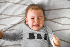 一岁的婴儿在床上哭