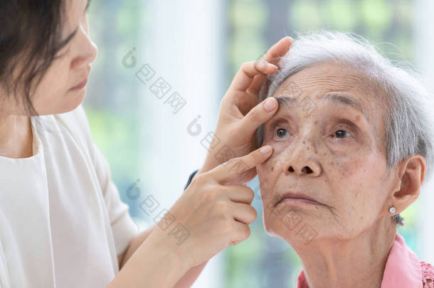医生检查老年女性病人的眼睛，眼科医生检查亚洲老年妇女的眼睛在诊所，健康概念