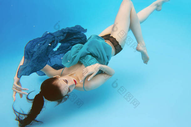 超现实，概念，艺术肖像美丽的美丽的黑发年轻女子与<strong>化妆水</strong>下在游泳池的蓝色背景