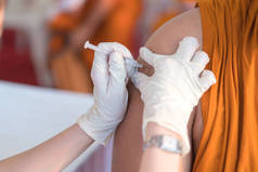 护士拿着注射器注射给病人注射疫苗