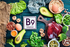 含有天然维生素B9的食物：肝脏、鳄梨、花椰菜、菠菜、欧芹、豆类、坚果，蓝色背景。顶部视图.