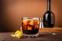 一杯浓浓的酒精饮料威士忌白兰地一个玻璃玻璃与冰块深木制背景。选择性聚焦.