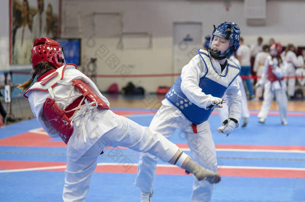 两个穿蓝色和红色拳道装备的女孩正在多阳战斗