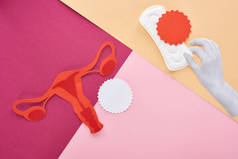 白手与卫生巾附近的女性生殖系统和空卡粉红色，紫色和米色背景