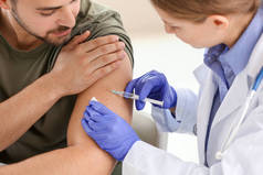 医生在诊所给年轻人接种疫苗